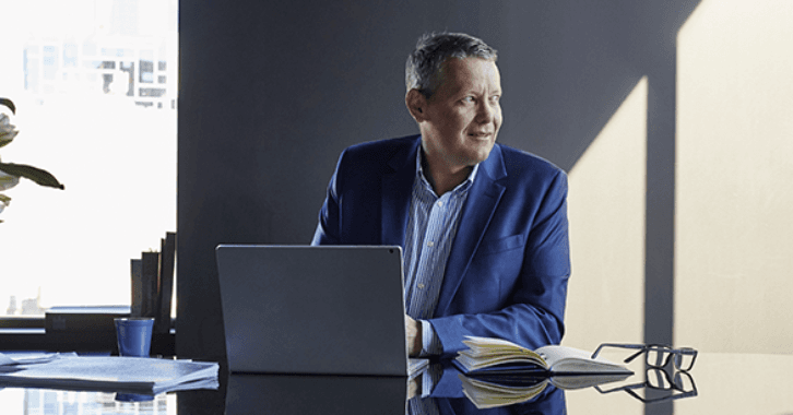 Picture of Whispir CEO Jeromy Wells sitting at a desk behind a computer.