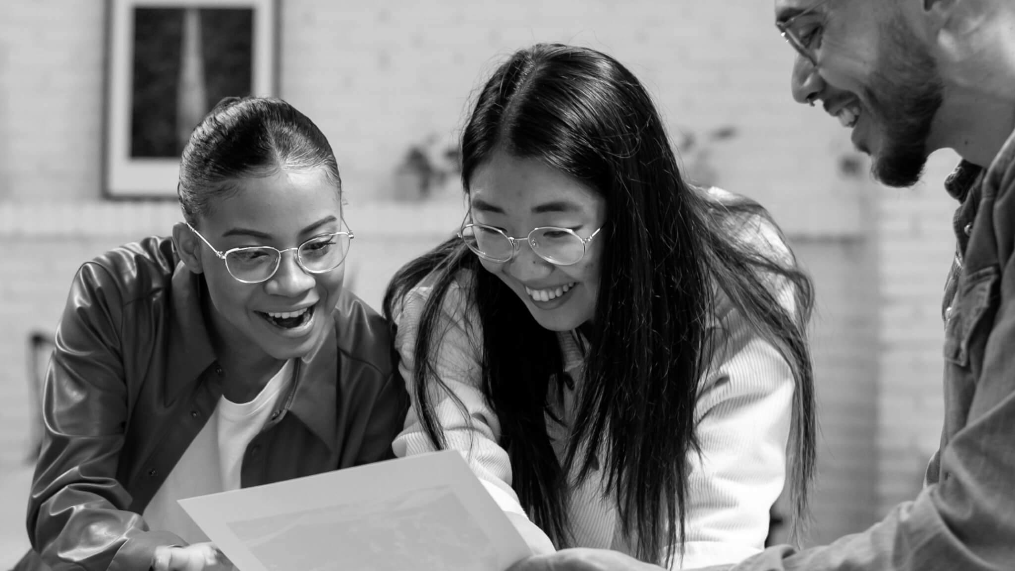 Three people look at a paper